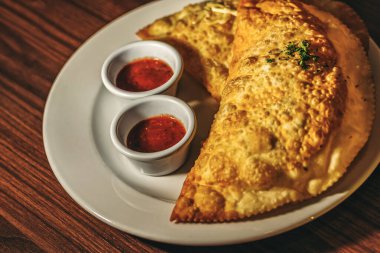 Et ve peynirli kızarmış turtalar, baharatlı domates sosu, cheburekler.