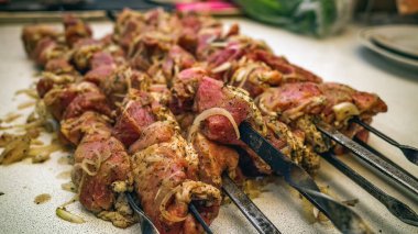 Soğan soslu et, ızgarada kızartılmaya hazır, yakın plan.