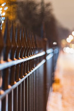 Kış akşamları dövülmüş metal çitler, seçici odaklanma, yakın plan.