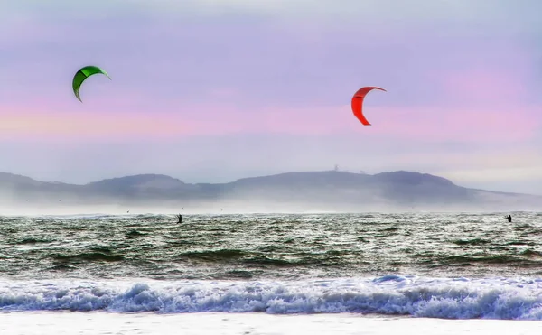 Kite surfers glijden op de golven van de Atlantische Oceaan. Extreme sport concept. Active leisure landschap — Stockfoto