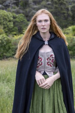 18. yüzyıl kadın işlemeli korse ile ıssız bir yerde duruyor.