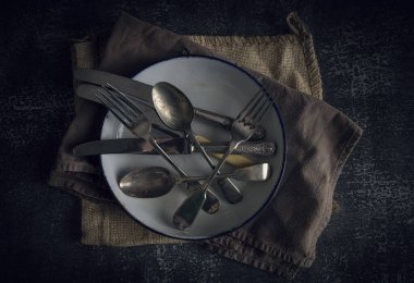 Teneke tabakta eski bir çatal bıçak.