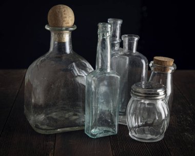 Kaba ahşap bir yüzeye dizilmiş eski şişe seçimi