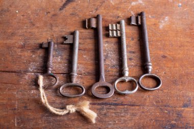 Sıkıntılı ahşap bir masanın üstüne yerleştirilmiş klasik metal tuşlar.