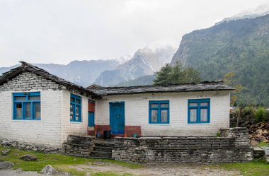 Evin dağlar gölgesi altında