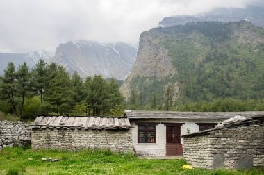 Evin dağlar gölgesi altında