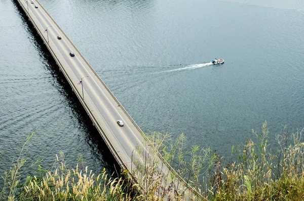 Barco que pasa bajo un puente sobre el río — Foto de Stock