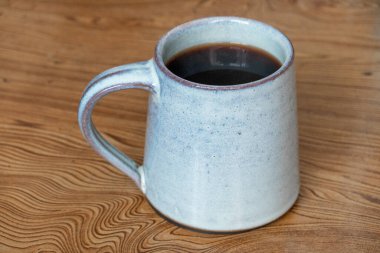 Bir kupa sıcak kahve ya da ahşap bir masada oturan Amerikano..