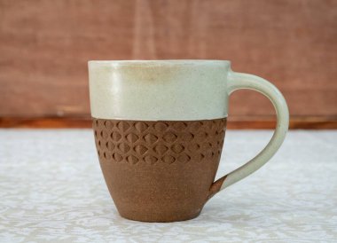 Beyaz bir bezle kaplı bir masanın üzerinde duran bir kahve fincanı..