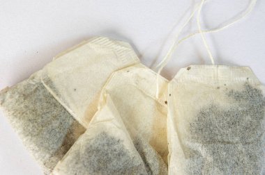 Beyaz arka planda üç kullanılmamış çay poşeti..