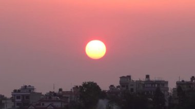 Sabahın erken saatlerinde Nepal 'in Katmandu şehrinde doğan güneşin güzel renkleri ve sabah bulanıklığı..