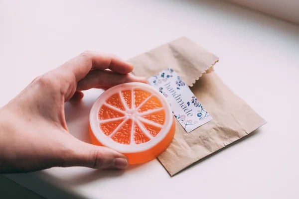 orange soap in female hand