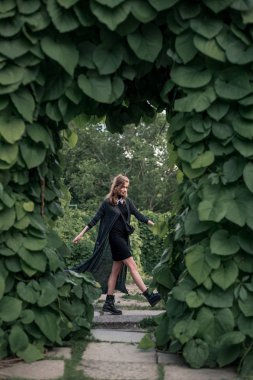 Kız kemer altında siyah uzun elbise içinde ayakta 