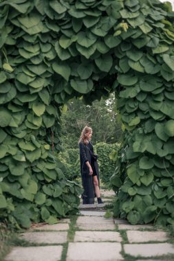 Kız kemer altında siyah uzun elbise içinde ayakta 