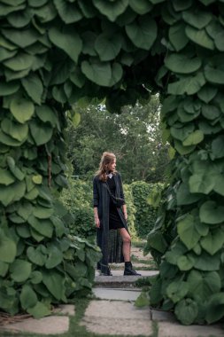 Kız kemer altında siyah uzun elbise içinde ayakta 