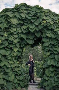 Kız kemer altında siyah uzun elbise içinde ayakta 