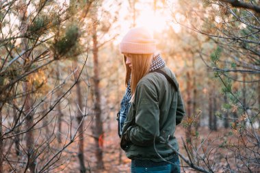 Kız pembe bir şapka giymiş ve yeşil bir ceket t standları