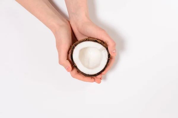Gesunde Ernährung. Frau hält eine Hälfte Kokosnuss isoliert auf weißem Hintergrund im Atelier — Stockfoto