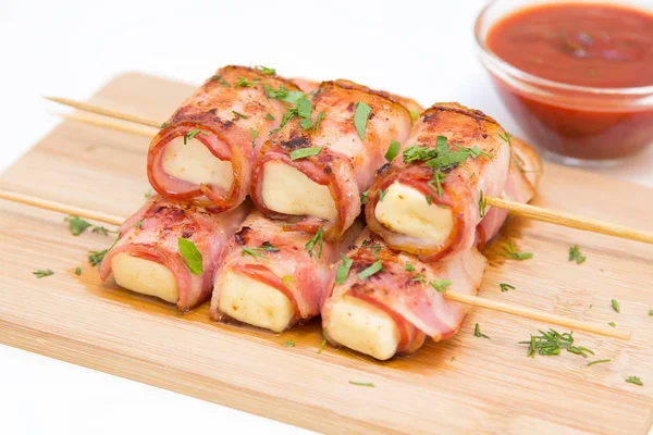 Rolls of feta cheese in bacon with spicy tomato sauce — Stock Photo, Image