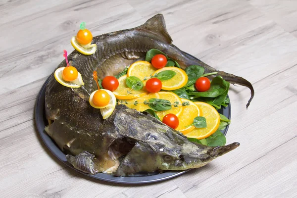 Stör mit Orangen, Spinat, Kirschtomaten und Physalis. Ganzes gebacken. — Stockfoto