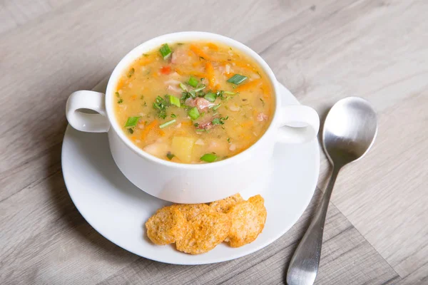 Sopa de ervilhas com carne, salsicha defumada e croutons — Fotografia de Stock