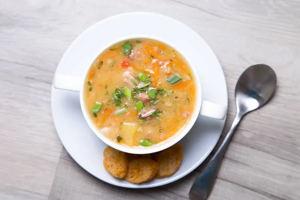 Гороховый суп с мясом, копченой колбасой и гренками — стоковое фото