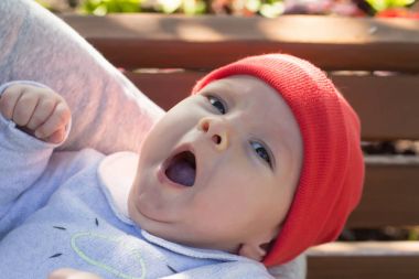 Bir yürüyüşe annesinin kollarında esneme yeni doğan bebek olduğunu. Yakın çekim.