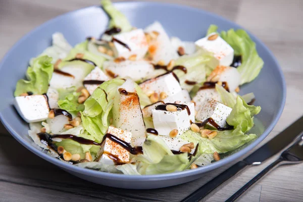 Salada com queijo feta, melões e nozes de cedro — Fotografia de Stock