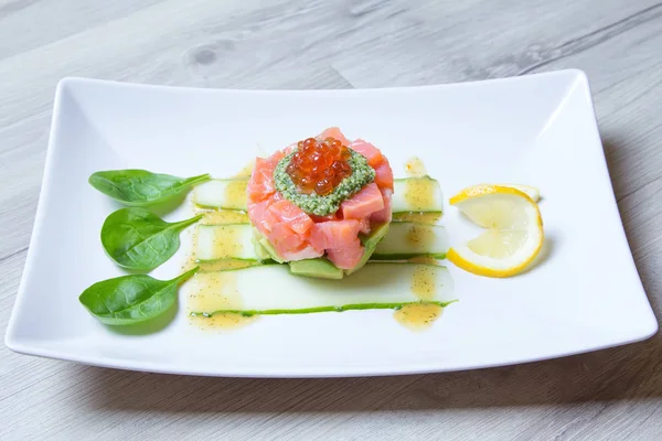 Tartare de salmão, caviar e abacate com molho de pesto e espinafre . — Fotografia de Stock