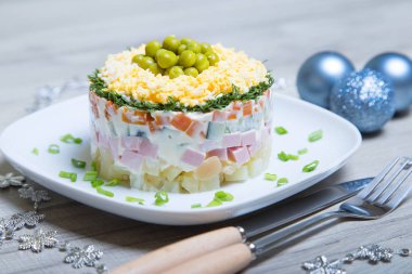 Geleneksel Rus salatası olivier beyaz bir plaka üzerinde