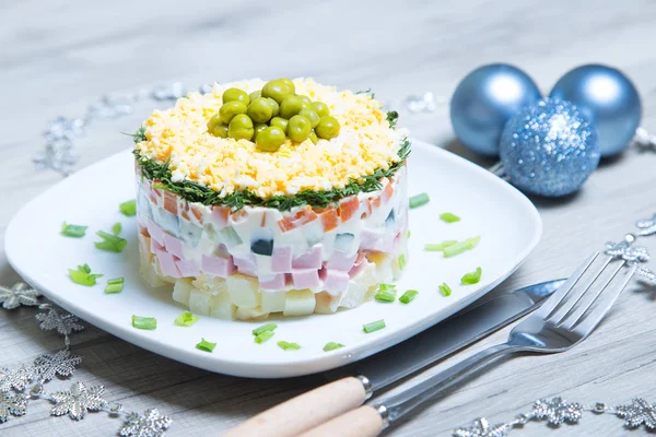 Salade traditionnelle russe olivier sur une assiette blanche — Photo