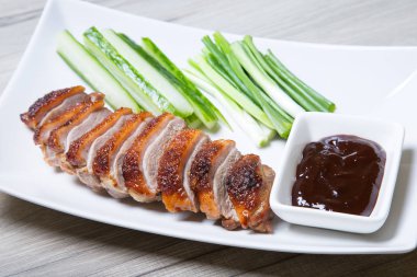 Baked duck with hoisin sauce, cucumbers and shallots clipart