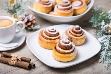 Tarçın, bir fincan kahve ile taze ev yapımı buns tarçın sopa. Seçici odak, yakın çekim