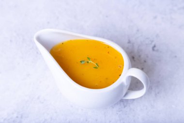 Beyaz sos kabında ördek (kümes hayvanları) için portakal sosu. Yakın çekim, seçici odaklanma.