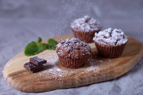 Chokladmuffins Träskiva Beströdda Med Issocker Hembakat Bakgrunden Finns Kopp Kaffe — Stockfoto