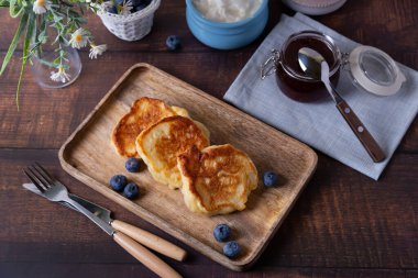 Ekşi krema, reçel ve yabanmersinli börek. Geleneksel Rus yemeği. Yakın plan..