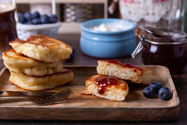 Ekşi krema, reçel ve yabanmersinli börek. Geleneksel Rus yemeği. Yakın plan..