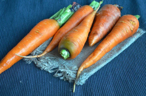 Taze havuç portre üzerinde karanlık bir masa örtüsü.