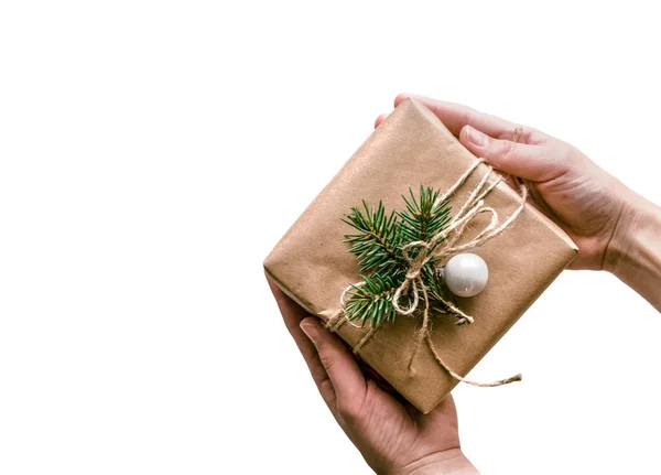 İzole hediye kraft kağıt Eko-tarzında dekore edilmiş beyaz zemin üzerine sarılı elinde. Noel arka plan iş veya metin sunumu için. — Stok fotoğraf