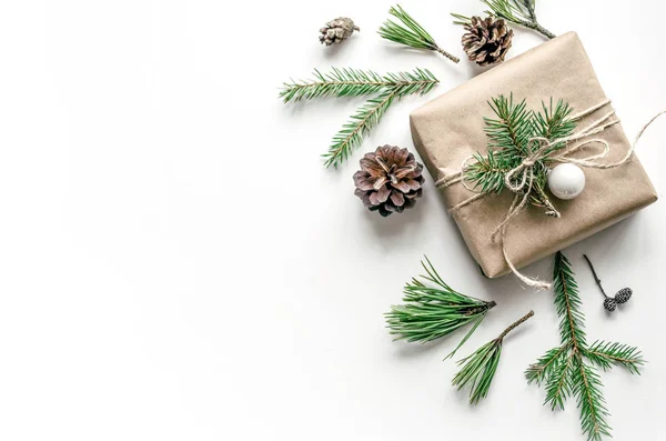 Beyaz zemin üzerinde bir hediye ile Noel kompozisyon. Eko-stil. Noel arka plan iş veya metin sunumu için