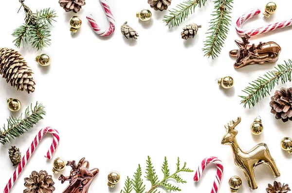 Christmas frame made of fir branches, cones and golden deers and sweets. — Stock Photo, Image