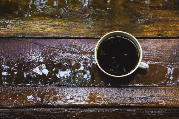 Cup of coffee on the wet boards — Stock Photo, Image