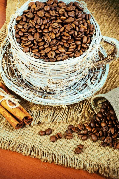 Taza de mimbre con granos de café y canela —  Fotos de Stock