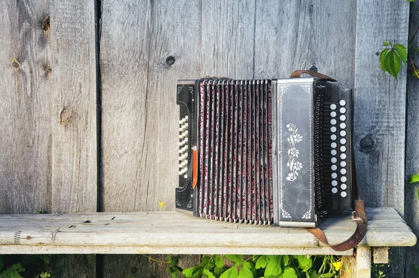 Die alte russische Ziehharmonika auf der Bank. — Stockfoto