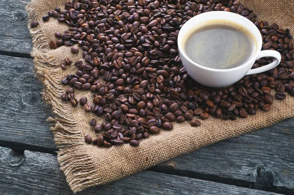 Café frito. Taza de café en el fondo de granos de café . —  Fotos de Stock