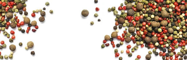 Beyaz üzerine izole edilmiş siyah, kırmızı ve beyaz biber taneleri. Baharat. Panorama. Pankart.