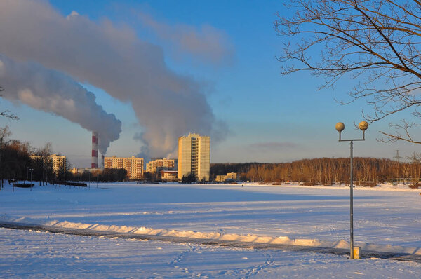 winter city and industrial smoke clouds the sky