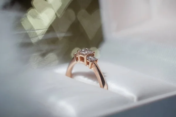 Anillo con diamante en una caja sobre el fondo de corazones. Fondo del Día de San Valentín — Foto de Stock