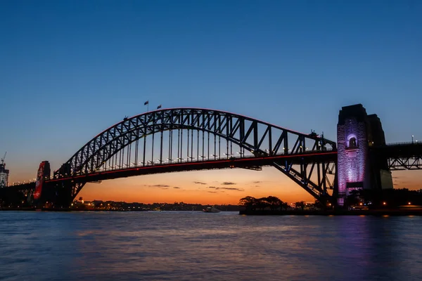 Освещённый мост Сиднейской гавани, вид с Киррибилли на закате — стоковое фото