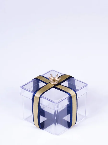 Şeffaf hediye kutusu ile bir altın kravat ve taç